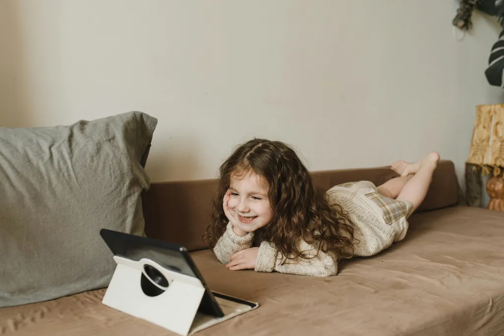 A child sitting on the floor and looking at a tablet